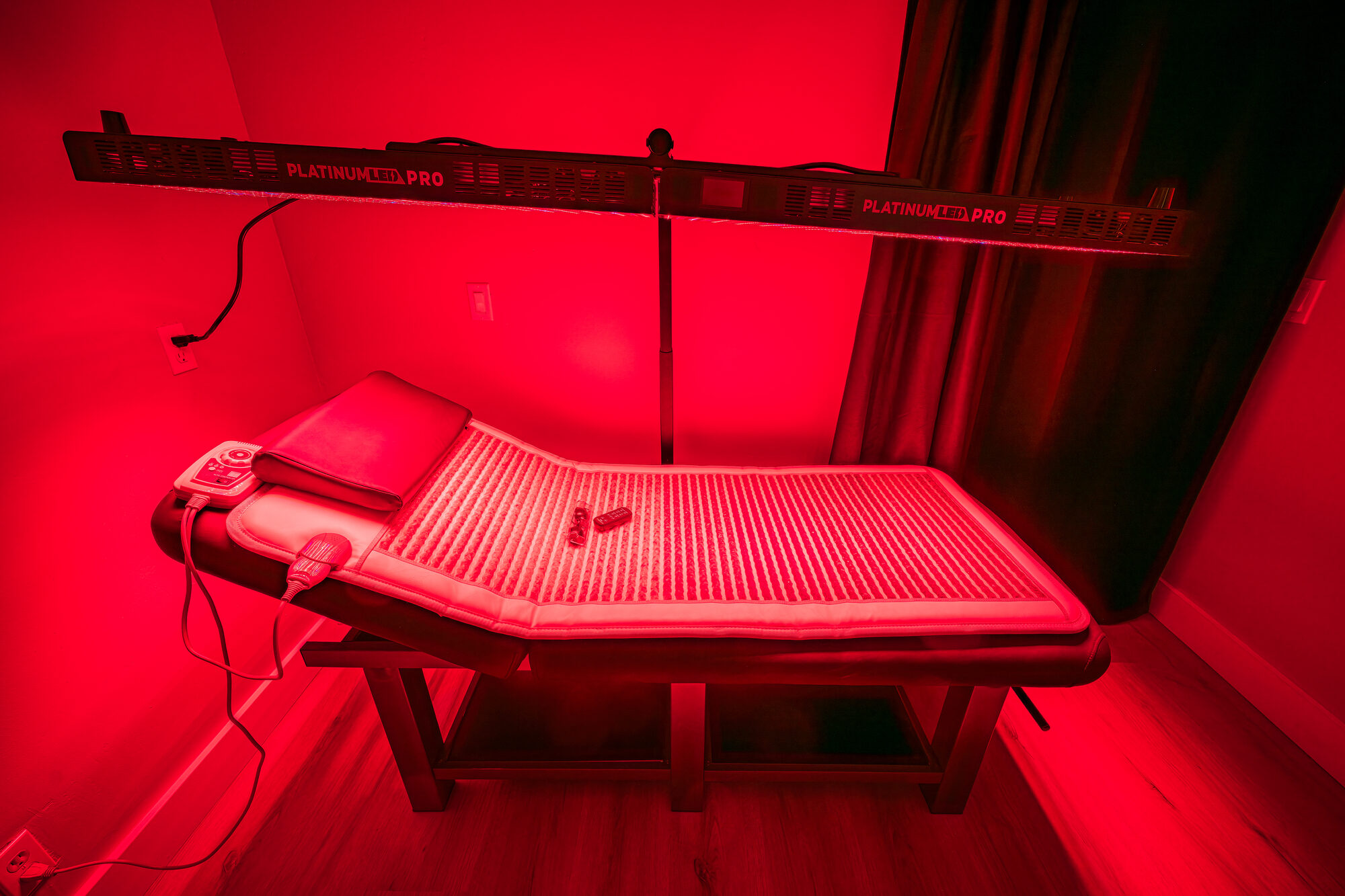 Guest relaxing under warm red light therapy panels at Arroyo Pinion wellness room